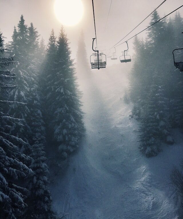 Blue fog and fire with mountains in the background and snowfall in